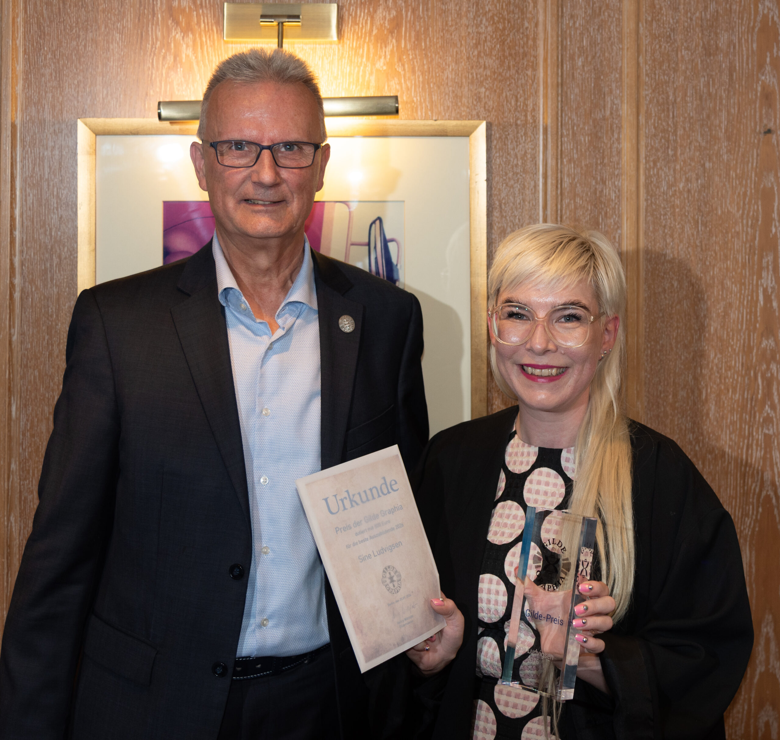 Sine Ludvigsen mit Urkunde und Gildepreis bei der Preisverleihung 2026 mit Henry Wittfoht